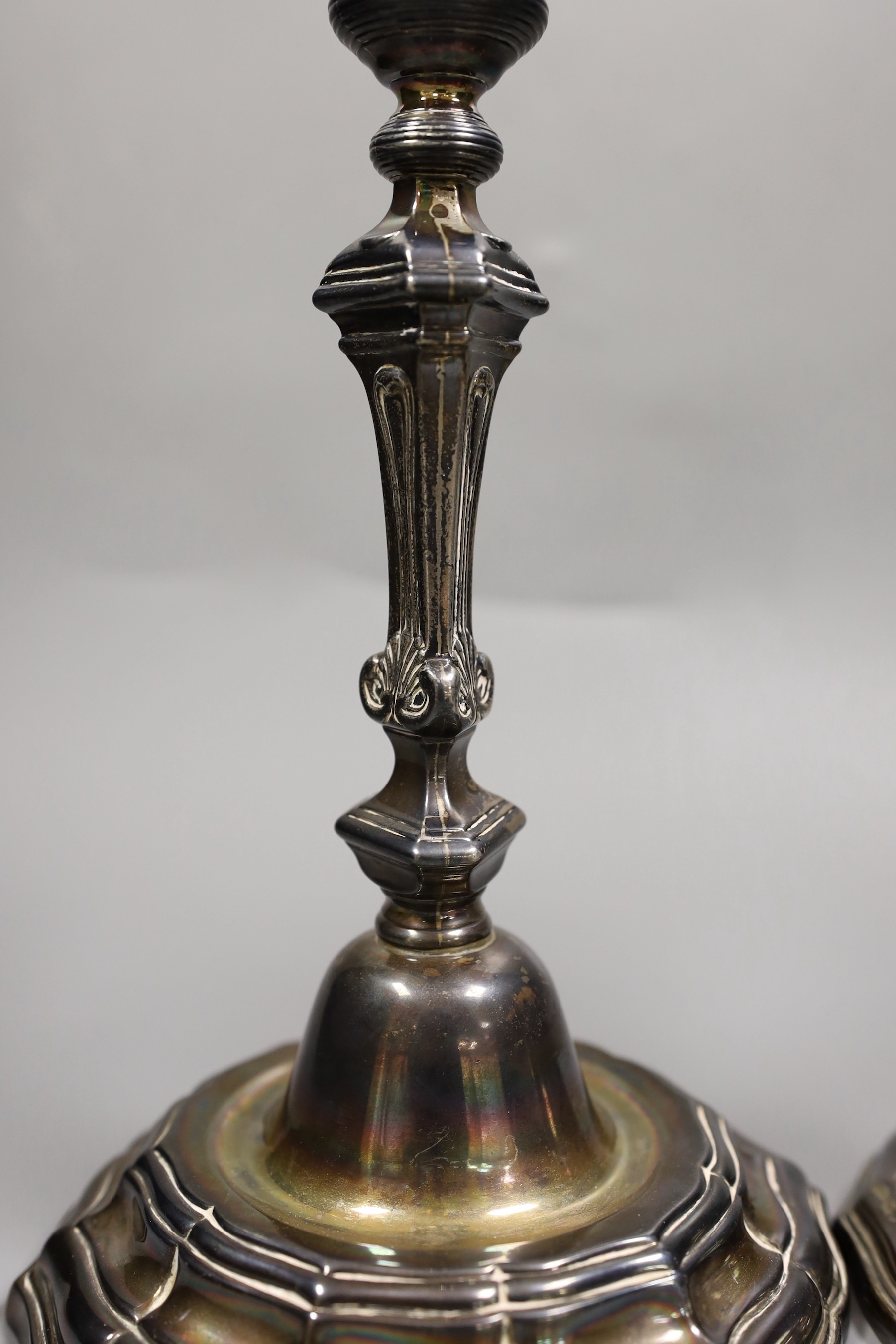 A pair of French Louis XVI cast white metal candlesticks and sconces, with waisted knopped stems, on shaped circular bases, maker, Jean Schoutheer, Dunkirk mark, circa 1775, height 26.2cm, 36oz.